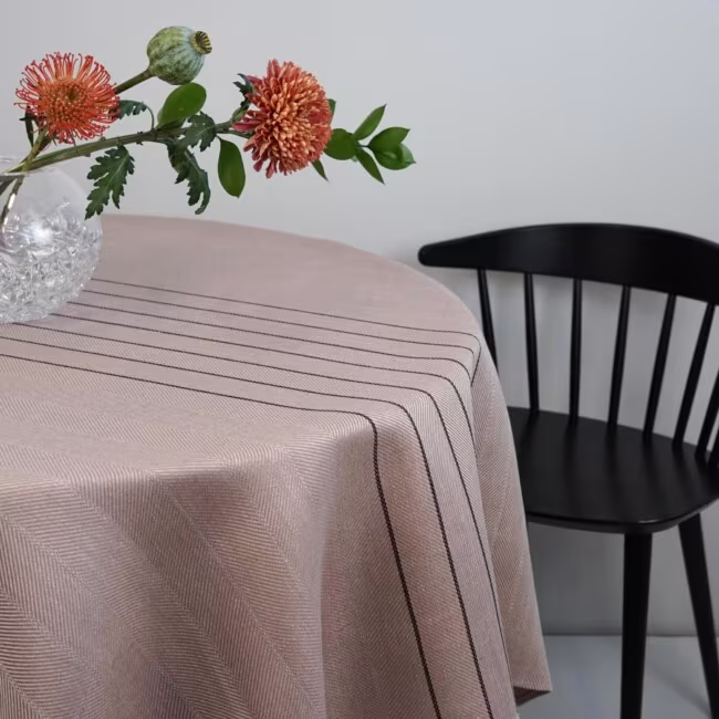 Gärdet tablecloth in powder pink on a round table with a black chair - klassbol linen vaveri