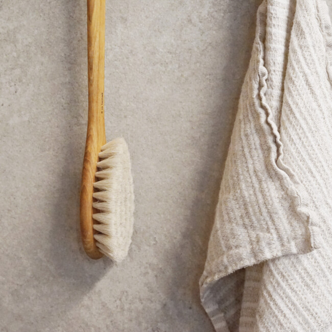 Iris hantverk badborste med en sand handduk