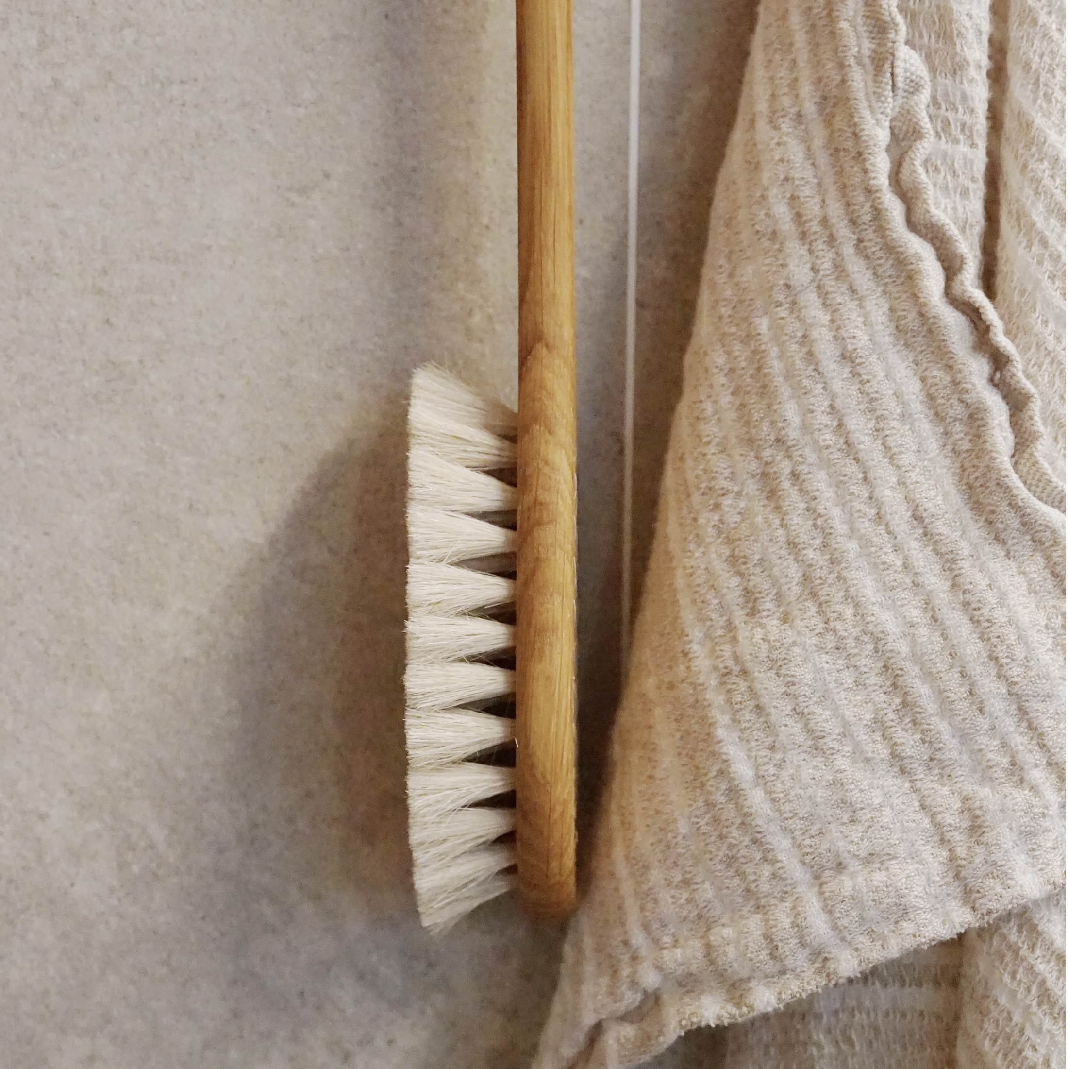 Iris hantverk badborste med en sand handduk