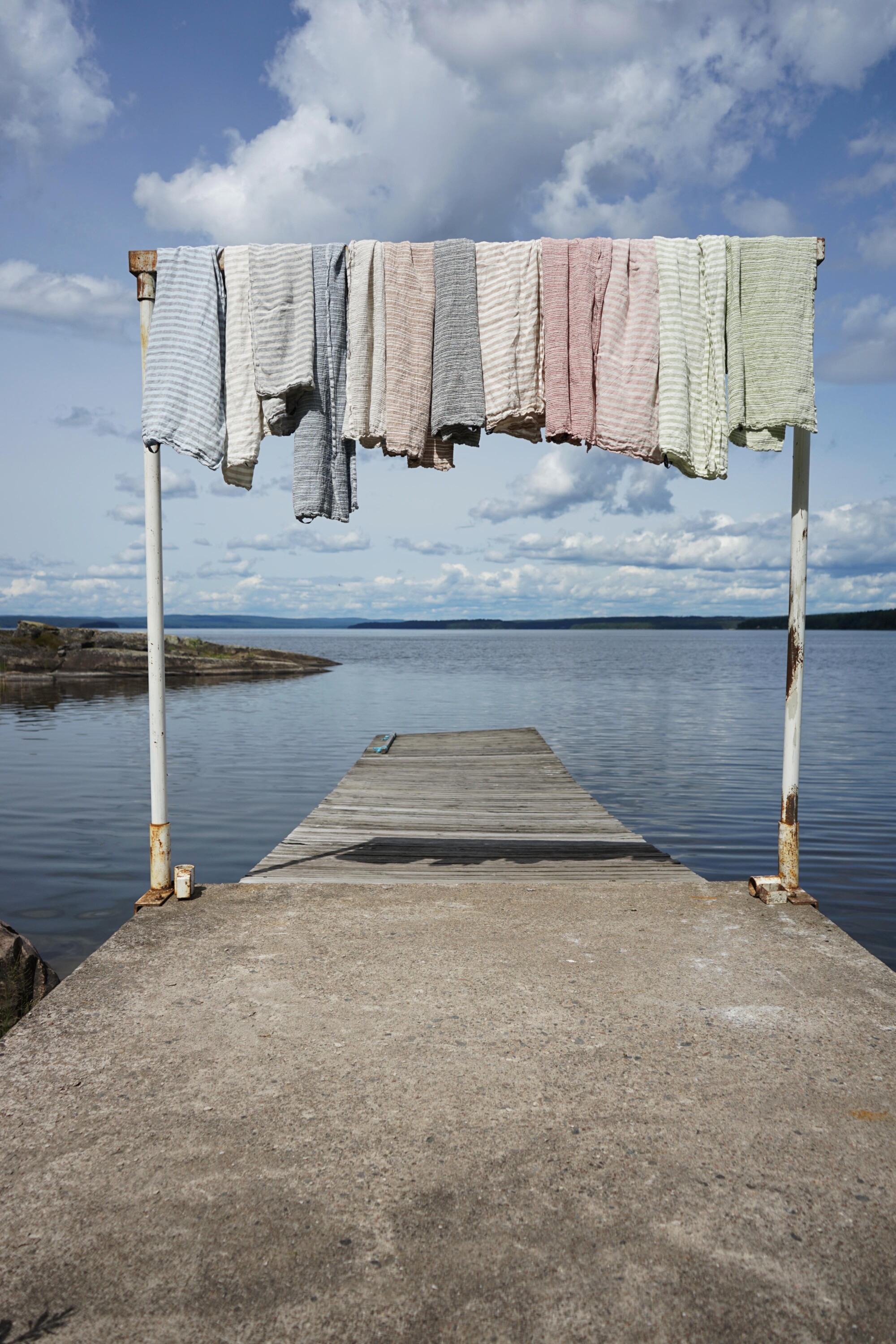 badhanddukar hänger i en ställning på en brygga