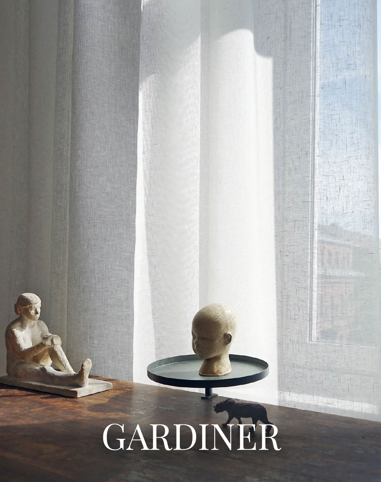 Gardiner vävda av Klässbols Linneväveri. I fönstret står även två vita skulpturer.