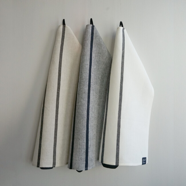 Samlingsbild av Kristina Starks glashanddukar, hänger mot en vit bakgrund.