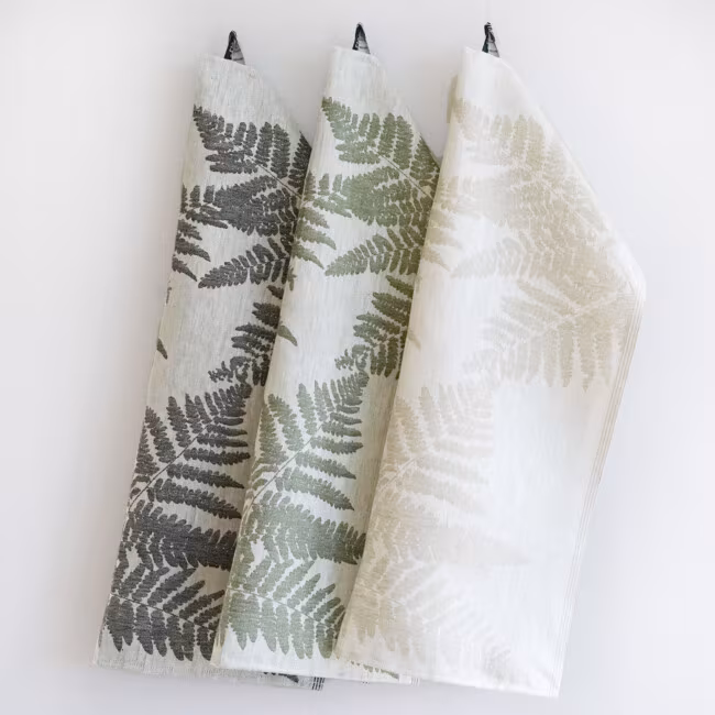 The linen towel ormbunke in a ormbunkepattern. Hanging against a light background.